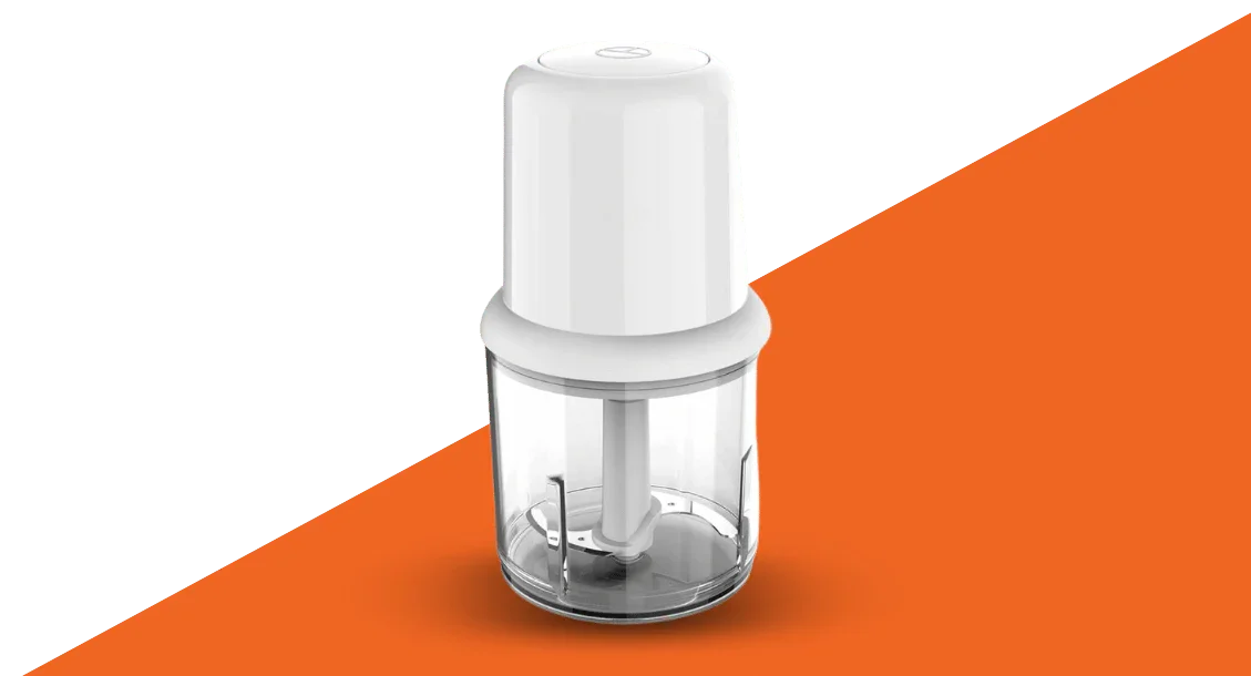 Electric food chopper with white lid and transparent container on an orange surface